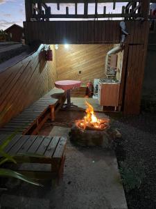 a fire pit with a picnic table and a bench at Vale de Cambara in Cambará