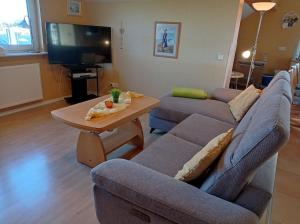 a living room with a couch and a table at Pension Kölzer in Mörsdorf