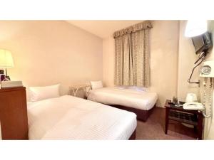 a hotel room with two beds and a telephone at Royal Hotel Uohachi - Vacation STAY 71048v in Toyota +34 photos