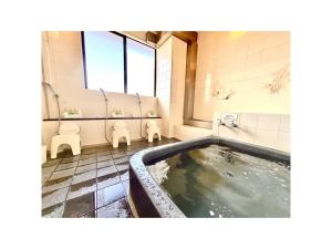 a bathroom with a hot tub and two toilets at Royal Hotel Uohachi - Vacation STAY 71048v in Toyota