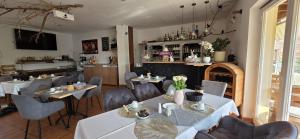 a restaurant with white tables and chairs and a counter at Pension Zur Alten Post in Havelberg
