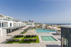 a resort with a swimming pool with chairs and umbrellas at Hotel Royal Atlántico in Puerto del Carmen