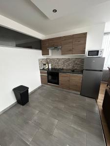 a kitchen with wooden cabinets and a refrigerator at apartment with balcony in Ronchin