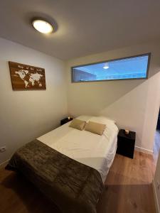 a bedroom with a bed and a large window at apartment with balcony in Ronchin