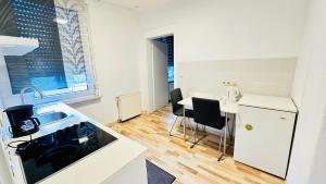 a kitchen with a sink and a table with chairs at Hotel am Freihafen in Duisburg