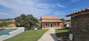 a house with a swimming pool next to a yard at Casa da Picoteira - Pool - Pets - EV Charger in Proença-a-Nova