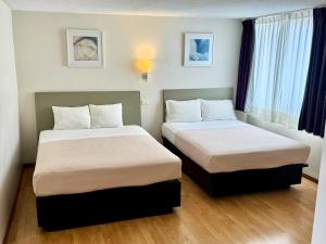 a room with two beds in a hotel room at Centro 19 Hotel in Querétaro