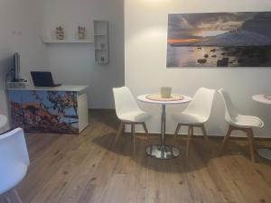 a room with a table and chairs and a painting at Tra Mare e Mito in Agrigento