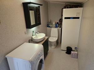 a laundry room with a washer and a sink and a refrigerator at Mulheidar in Leynar +16 photos