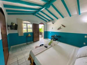 a bedroom with a large white bed with blue walls at Amara Hotel in Doradal