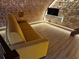 a couch in a living room with a brick wall at Il Rivellino in Marostica