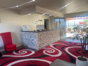 a lobby with a counter and a red chair at RELAX hotel and spa in Desert Hot Springs