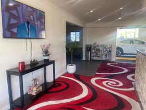 a lobby with a red carpet and a tv on the wall at RELAX hotel and spa in Desert Hot Springs