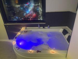 eine Badewanne mit Beleuchtung vor einem Fenster in der Unterkunft Anı Park Hotel in Pendik