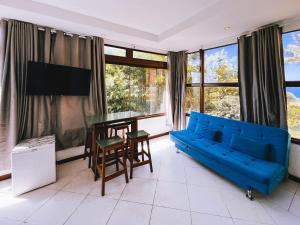 a living room with a blue couch and a table at Sentinelas do Mar in Arraial do Cabo