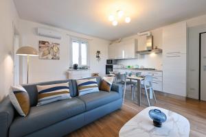 a living room with a blue couch and a kitchen at Lora Luxury Suite 6 ,free private parking, self check in, air conditioner in Como