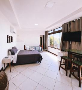 a bedroom with a bed and a piano at Sentinelas do Mar in Arraial do Cabo