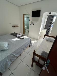 a bedroom with a bed and a television in it at Refugio Caiçara in Cananéia