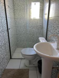 a bathroom with a toilet and a sink at Refugio Caiçara in Cananéia