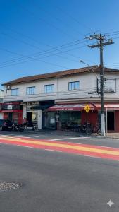 a building on the side of a street with cars parked in front at Refugio Caiçara in Cananéia