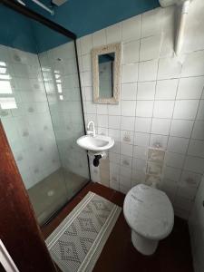 a bathroom with a shower and a toilet and a sink at Refugio Caiçara in Cananéia +6 photos