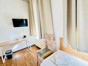 a bedroom with a bed and a desk and a tv at Hotel am Freihafen in Duisburg