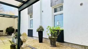 a white house with a door and some plants at Hotel am Freihafen in Duisburg