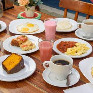 a table with plates of breakfast food and a cup of coffee at Residencial Villa Jeri - AP with balcony, optional BREAKFAST in Jericoacoara