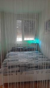 a white bed with a cage in a room at Apartman Suva reka in Leskovac