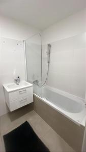 a white bathroom with a sink and a shower at Aurora Apartment in Vienna +3 photos