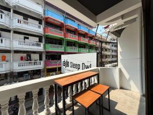 a balcony with two benches in front of a building at Sleep Owl Jomtien in Jomtien Beach