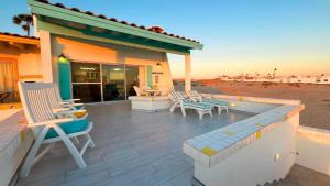 a patio with lounge chairs and a table and avisor at Cozy & Colorful Beachfront Condo Las Olas I 28 in Puerto Peñasco +26 photos