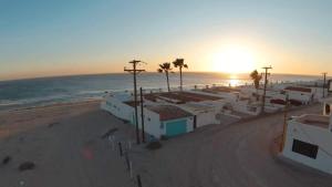 a view of a beach with palm trees and buildings at Cozy & Colorful Beachfront Condo Las Olas I 28 in Puerto Peñasco