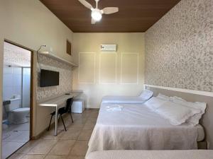 a bedroom with a bed and a desk and a television at Espaço Malongo in Sarzedo