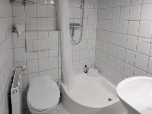 a white bathroom with a toilet and a sink at Charmanter Bungalow in Neubukow nahe der Ostsee in Neubukow +21 photos