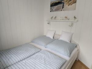 two beds in a corner of a room at Charmanter Bungalow in Neubukow nahe der Ostsee in Neubukow