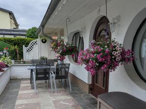 a patio with a table and chairs and flowers at Charmanter Bungalow in Neubukow nahe der Ostsee in Neubukow