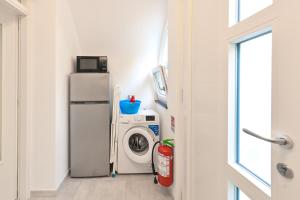 a laundry room with a refrigerator and a washing machine at Lucia's Apartments in Ischia Town