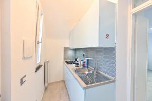 a small kitchen with a sink and a refrigerator at Lucia's Apartments in Ischia Town