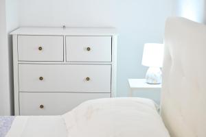a bedroom with a white dresser and a bed at Lucia's Apartments in Ischia Town