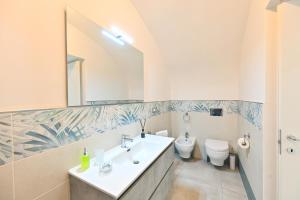 a bathroom with a sink and a toilet and a mirror at Lucia's Apartments in Ischia Town