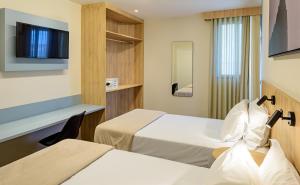 a hotel room with two beds and a tv at Rio Hotel by Bourbon Batel - Curitiba in Curitiba