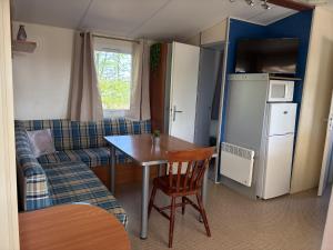 a small living room with a table and a couch at camping de la mottelette in Forest-Montiers