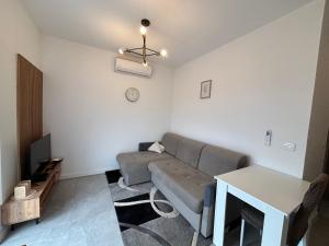 a living room with a couch and a table at Apartman Bugenvila Postira Brač in Postira