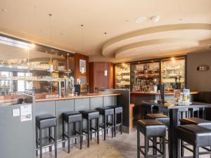 a bar in a restaurant with black stools at Hambachtal forest hideaway boutique resort in Oberhambach