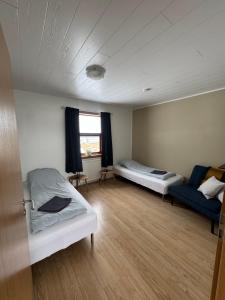 a room with two beds and a couch in it at Guesthouse Myrkholt II in Tungufell