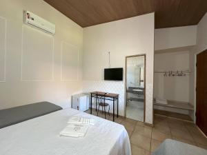 a bedroom with a bed and a table and a mirror at Espaço Malongo in Sarzedo +23 photos