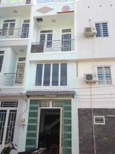a large white building with a door and a balcony at homestay Huynh DC in Ho Chi Minh City