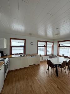 a large white kitchen with a table and chairs at Guesthouse Myrkholt II in Tungufell