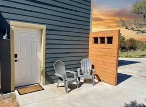 two chairs sitting on a patio next to a house at Ranchette Apartment- beach access small lake view in Buchanan Dam